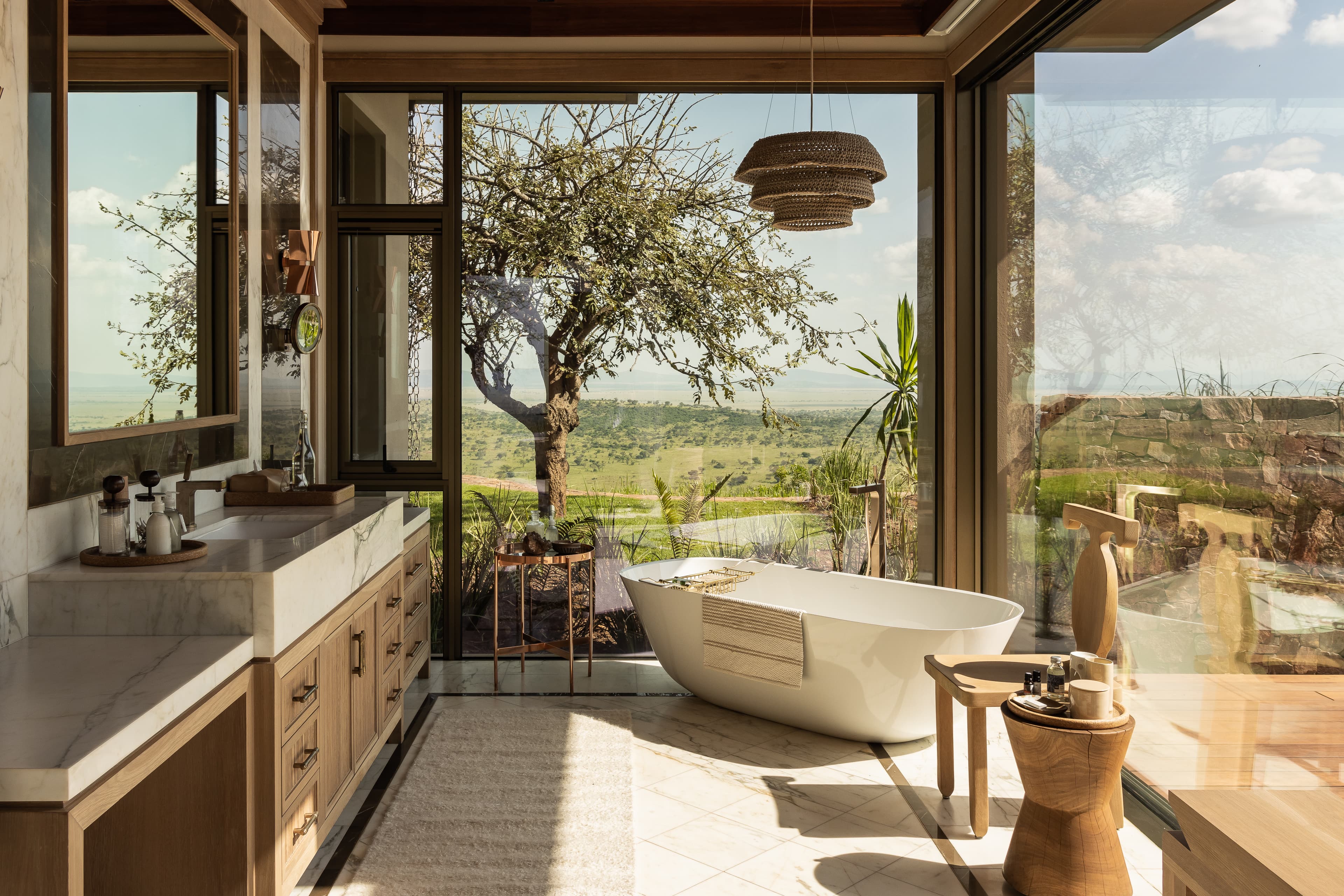 Singita Milele — main suite bathroom with freestanding bath and floor-to-ceiling views over the Serengeti