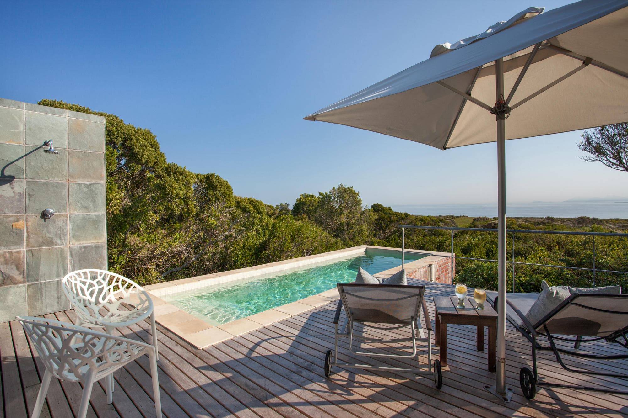 A private villa pool deck above the fynbos with the Walker Bay coastline beyond